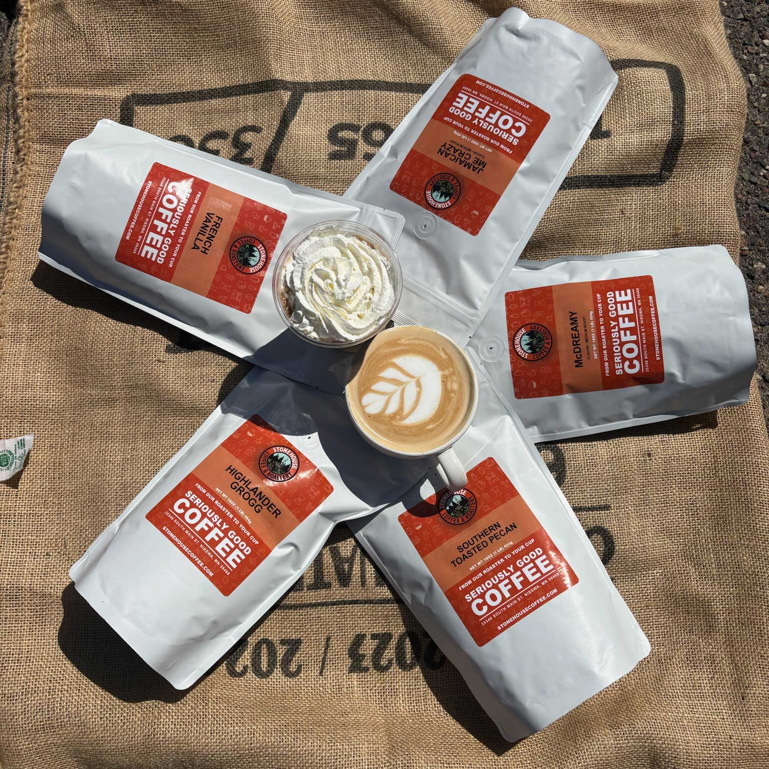 Stonehouse Coffee packages with a cup of coffee on a rustic background
